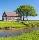 Romantische huis en bomen op een Nederlandse dijk aan het water Stockfoto - 13843392